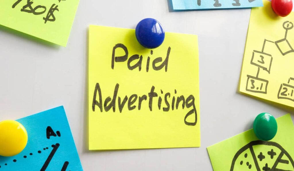 Close-up of colorful sticky notes pinned to a board, with Paid Advertising prominently displayed on a yellow note.